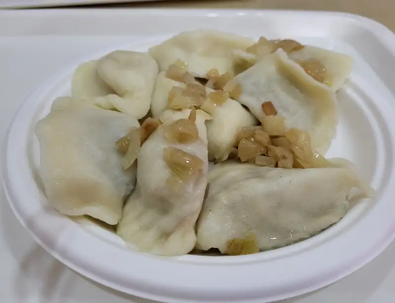 Porcja pierogów z okrasą na talerzu